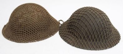 Two WWII British Mk II steel helmets with netting and original liners: dated 1941 and 1943 (2)