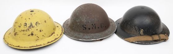 Three WWII Mk II pattern 'Factory' steel helmets: one in yellow with black 'B.
