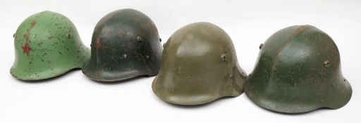 A group of four Eastern European steel helmets: possibly variations of the German M40 pattern with