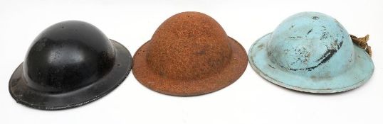 Two WWII MKII pattern steel helmets: one in blue the other with rusted shell and remains of