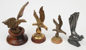 Four brass bird car mascots: comprising an eagle with outstretched wings on a wooden socle,