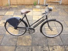 A Raleigh Sports lady's bicycle: all steel step through frame, black with gold lettering,