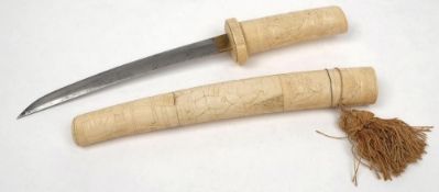 An early 20th century bone-handled Tanto: the short blade with landscape carved single piece grip