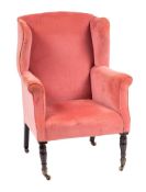 A stained mahogany wing frame armchair:, fully upholstered in pink dralon velvet, on turned legs,