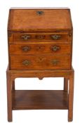 A fruitwood bureau of small size:, on a later oak stand,