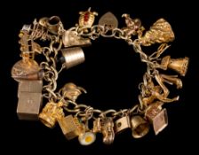 A 9ct gold curb-link bracelet with twenty four various attached mostly 9ct gold hallmarked charms: