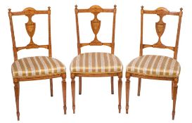 A set of four late 19th century Sheraton Revival satinwood and marquetry salon chairs:,