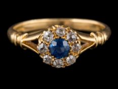 A Victorian sapphire and diamond circular cluster ring: between splayed shoulders, ring size J.