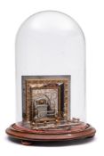 A steel and gilt metal miniature model of a fireplace: of rectangular outline, with tiled back,