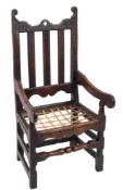 A late 17th Century oak open armchair:, the back with shaped top rail and pierced centre,