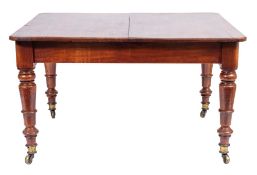 A Victorian mahogany extending dining table with two leaves: on turned volute tapered legs