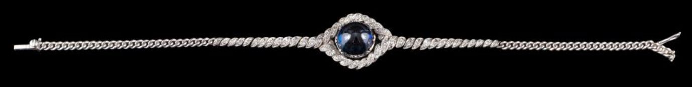 A sapphire and diamond bracelet: the central circular cabochon sapphire within a twisted surround