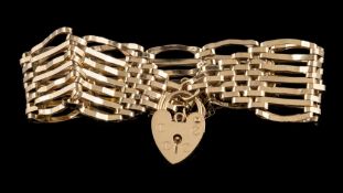 A 9ct gold seven bar, gate-link bracelet: with attached heart-shaped padlock clasp and safety chain,