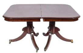 A Regency mahogany twin-pillar dining table:, the top with rounded corners and a moulded edge,