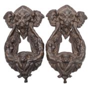 A pair of cast bronze patinated door knockers: with grotesque mask mount,