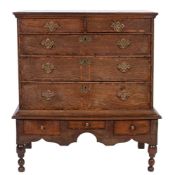 An 18th Century oak and crossbanded chest on a later stand:, the upper part with a moulded top,