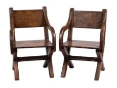 A pair of oak X-frame armchairs of Glastonbury type:, with rectangular backs,