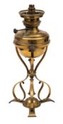 An Arts and Crafts period brass lamp: with brass reservoir and mounted on three scrolling supports