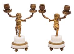 A pair of late 19th century ormolu and white marble figural twin branch candelabra: with urn shaped