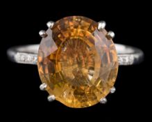 A platinum, topaz and diamond dress ring: the oval topaz approximately 13mm long x 11.