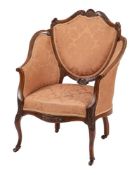 An Edwardian carved mahogany salon armchair:,