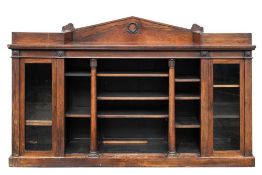 A Regency rosewood bookcase/display cabinet:, the sunken centre with an angled arch ledge back,