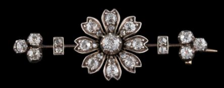 A diamond flower head brooch: the central flower head set with old cut and rose cut diamonds,