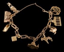 A 9ct gold bracelet with nine various attached gold charms: to include soldier on horse and dice