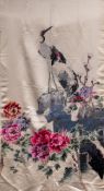 A Chinese embroidered silk panel: depicting two cranes perched on rockwork with flowering peonies