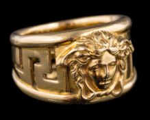 An 18 carat gold ring by Versace: designed with a Medusa's head on a pierced Greek key shank,