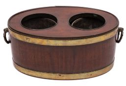 A Georgian mahogany and brass bound wine cooler: of oval outline and coopered construction,