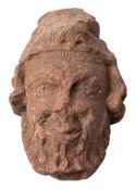 A carved sandstone head of a bearded man: wearing a coronet, with wavy hair, 23cm high.