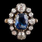 A sapphire and diamond ring: the central oval cut sapphire claw set within a surround of old cut