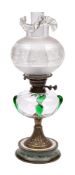 An Art Nouveau period oil lamp: with clear and green glass overlay reservoir on a waisted brass