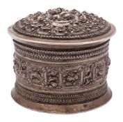 A Burmese white metal box and cover: of cylindrical outline,