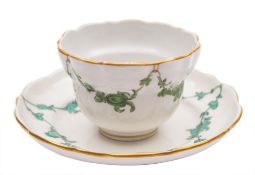 A Bristol tea bowl and saucer: of fluted ogee form, painted in green monochrome with floral swags,