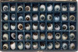 An Optician's case of fifty glass eyes: in blues, greens and brown colours,