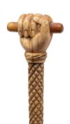 A 19th century marine ivory walking cane with carved pommel in the form of a fist holding a