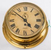 A Sestrel circular brass bulkhead clock: the dial with Roman numerals and subsidiary seconds dial