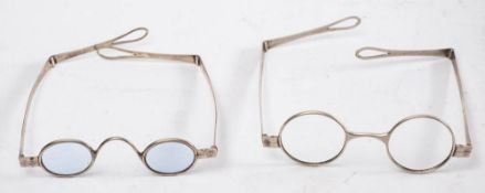 Two pairs of 19th century white metal spectacles:, one pair with lightly tinted oval lenses,
