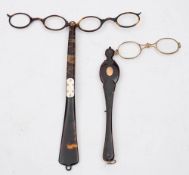 A pair of gold inlaid tortoiseshell lorgnettes: the spring loaded gilt frames in a shaped