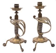 A pair of Victorian sword hilt gilt and spur gilt brass candlesticks: each sconce with tridecagon