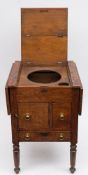 A ship's teak drop flap enclosed washstand: the double hinged top enclosing wash bowl and cup wells,