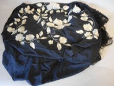 A Victorian black silk shawl: embroidered with white flowerheads and foliage with netted black