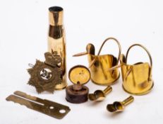 Three pieces of trench art: , a button polisher, travelling inkwell, car badge.