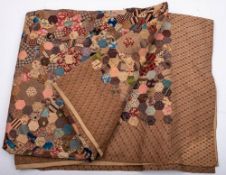 A large early 20th century patchwork quilt: the central field made of hexagonal polygons in a