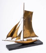 A bronze model of a yacht: with single mast, mounted on a rectangular wood base 37cm long.