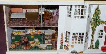 A mid-20th Century tinplate fronted doll's house: the pitched roof over sliding front enclosing