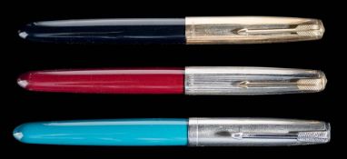A group of three Parker 51 fountain pens: one teal with lustraloy cap,