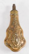 A copper and brass powder flask: with spring loaded measure over a shaped repousé decorated body,